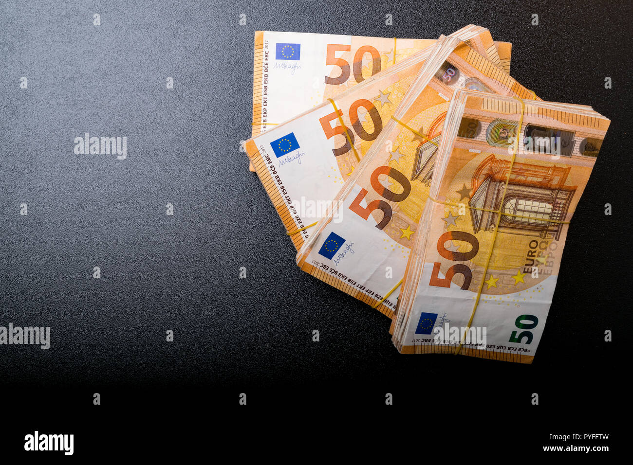 Pila di 50 real banconote da 50 euro banconote sotto la banda di gomma, isolato su sfondo nero. Circa 2500 euro Foto Stock