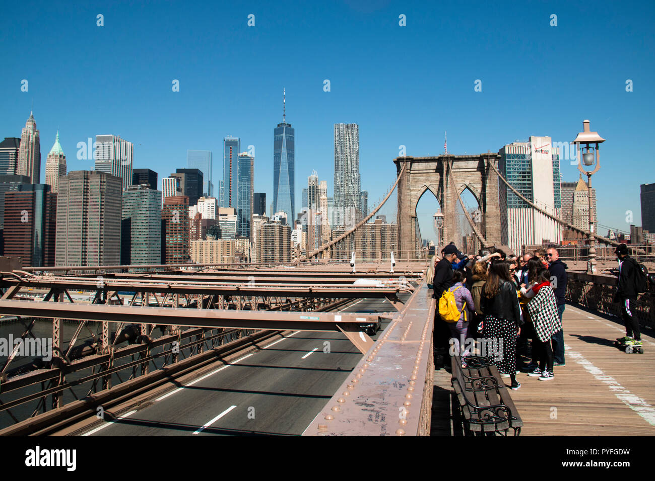 La città di NEW YORK, Stati Uniti d'America - Aprile 2018: persone sul pittoresco ponte di Brooklyn con lo skyline di Manhattan in background in New York City, Stati Uniti d'America Foto Stock
