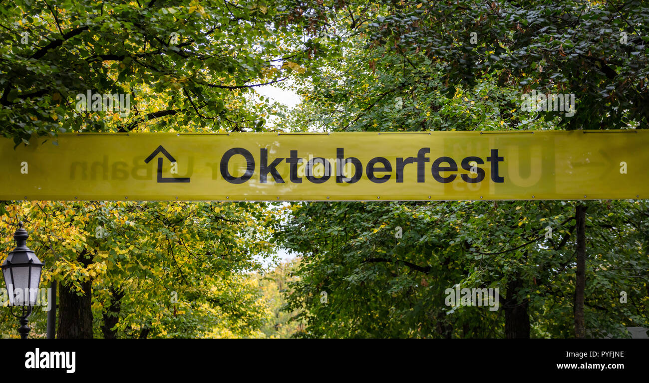 Oktoberfest, Baviera, Germania. Ingresso alla fiera, giallo cartello informativo, testo oktoberfest, verdi alberi sullo sfondo Foto Stock