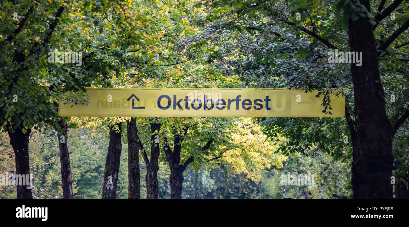 Oktoberfest, Baviera, Germania. Ingresso alla fiera, giallo cartello informativo, testo oktoberfest, verdi alberi sullo sfondo Foto Stock