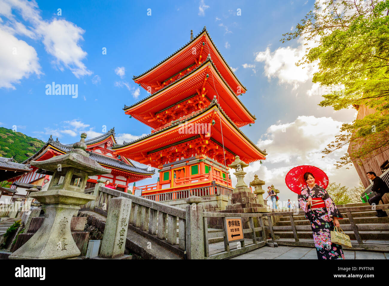 Kyoto, Giappone - 24 Aprile 2017: donna indossare il kimono e ombrellone in piedi nella pagoda rossa del tempio di Kiyomizu. Kiyomizudera è Patrimonio Mondiale di UNESCO e il famoso punto di riferimento in Kyoto. Stagione primaverile, sunset shot Foto Stock