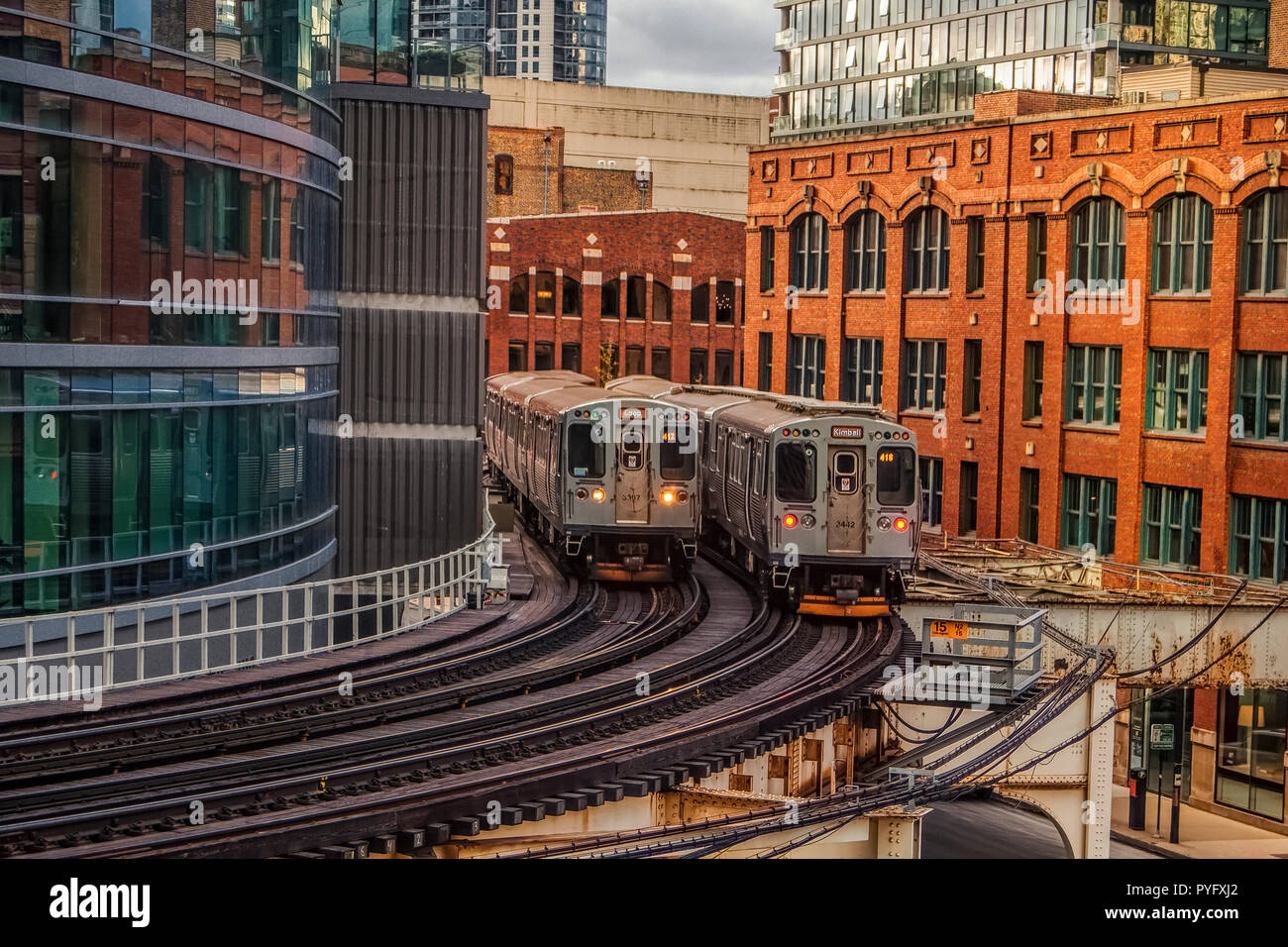 Due treni pendolari incrocio sulla curva, tracce elevata in Chicago Foto Stock
