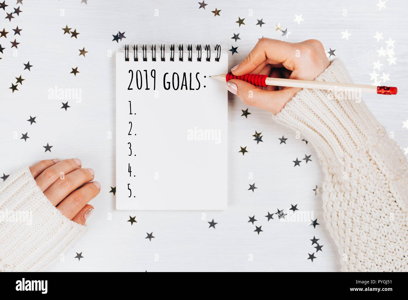 Decorazioni per le vacanze e il notebook con la lista dei desideri su bianco tavolo rustico, piatto stile di laici. Il concetto di pianificazione. Foto Stock