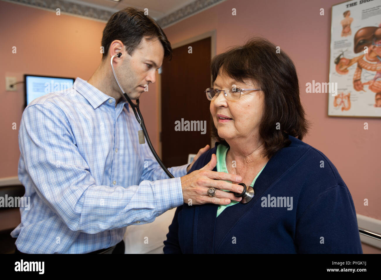 Medico esamina un paziente con stetoscopio. Foto Stock