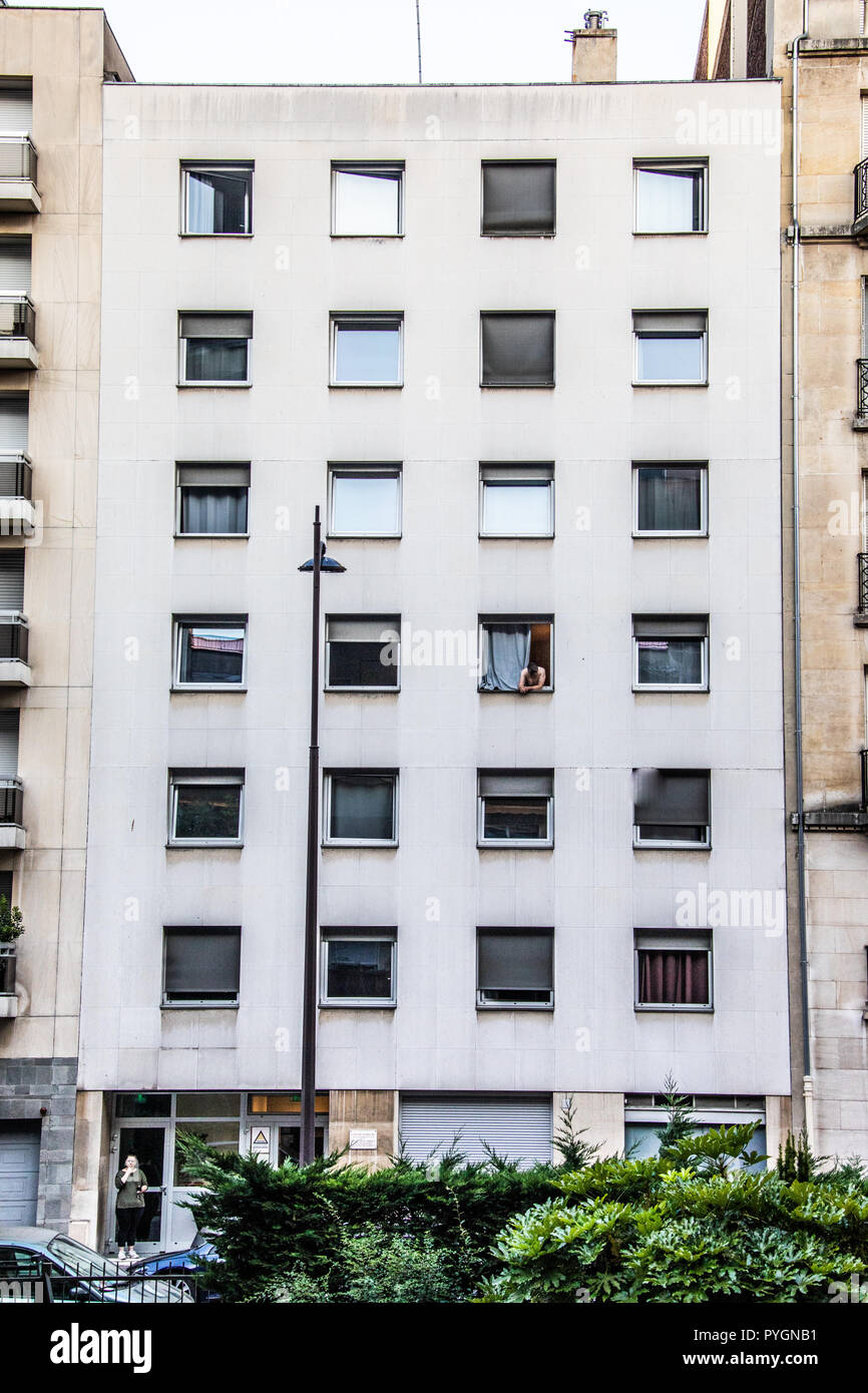 L uomo nella finestra di un edificio di appartamenti, Parigi, Francia Foto Stock