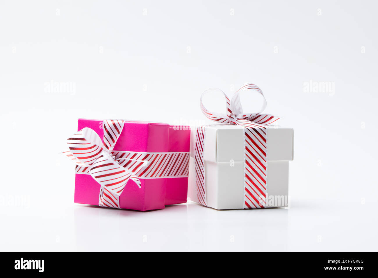 Rosa e Bianco confezione regalo legato con il bianco red stripe ribbon Foto Stock
