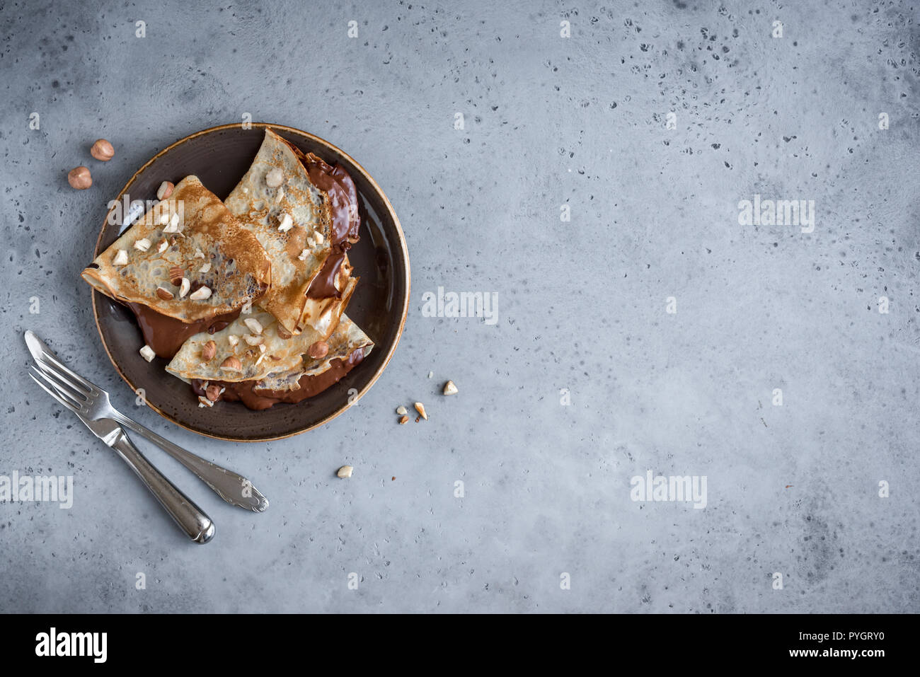 Crepes con diffusione di cioccolato e nocciole. In casa crespelle sottili per la prima colazione o per dessert. Foto Stock