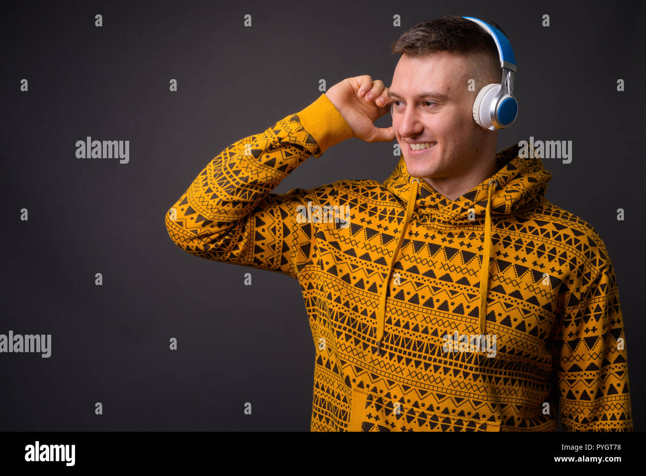 Felice giovane uomo bello ascoltare musica con le cuffie Foto Stock