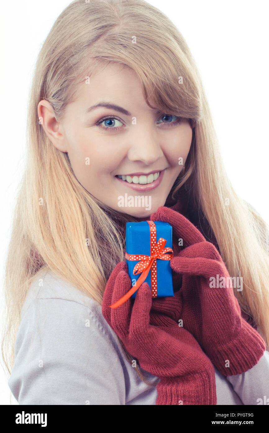 Foto d'epoca, donna sorridente in guanti di lana avvolto di contenimento regalo per Natale, Valentino, compleanno o altra celebrazione, sfondo bianco Foto Stock