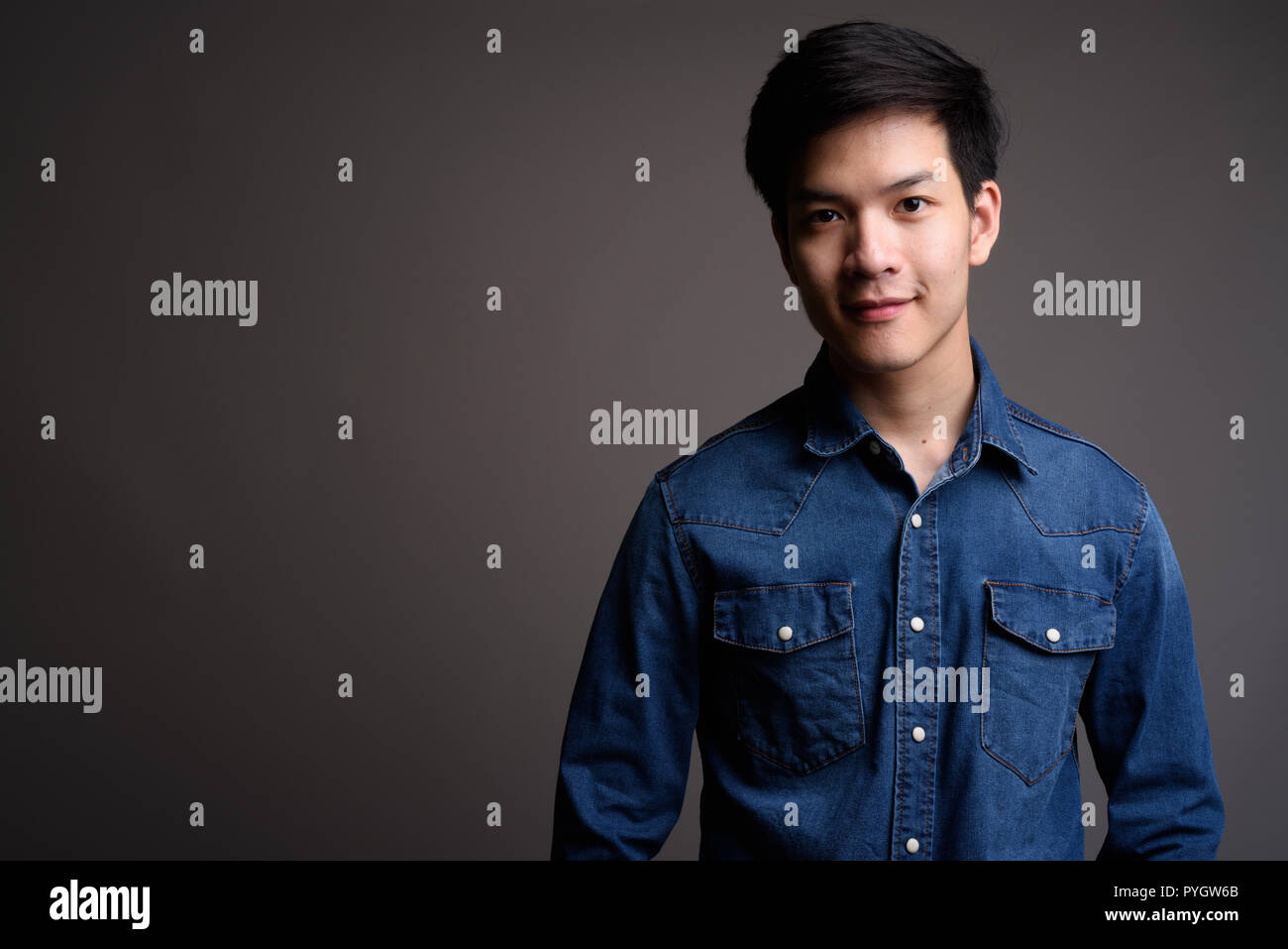 Bel giovane uomo asiatico indossando il denim shirt Foto Stock