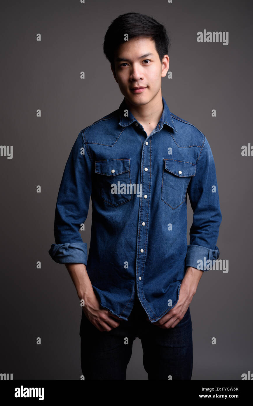 Bel giovane uomo asiatico indossando il denim shirt Foto Stock