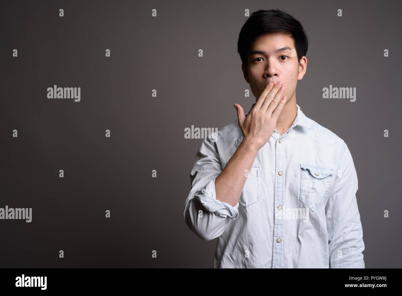Bel giovane imprenditore asiatica guardando scioccato e sorpreso Foto Stock