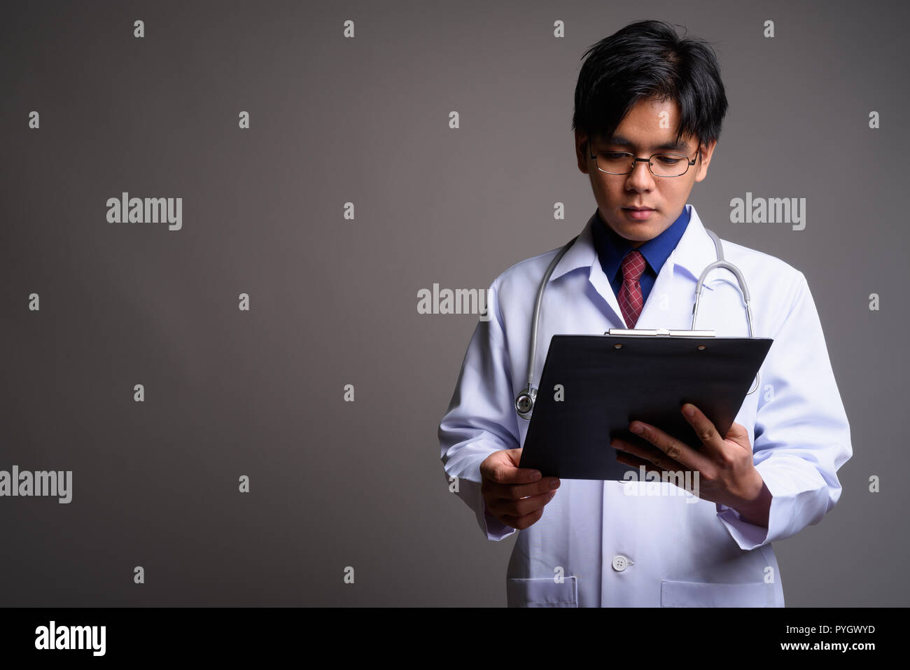 Ritratto di giovane uomo asiatico medico checklist di lettura dagli appunti Foto Stock