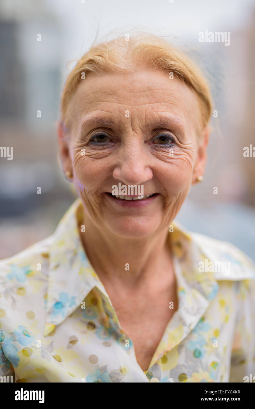 Felice senior bella donna sorridente all aperto in città Foto Stock