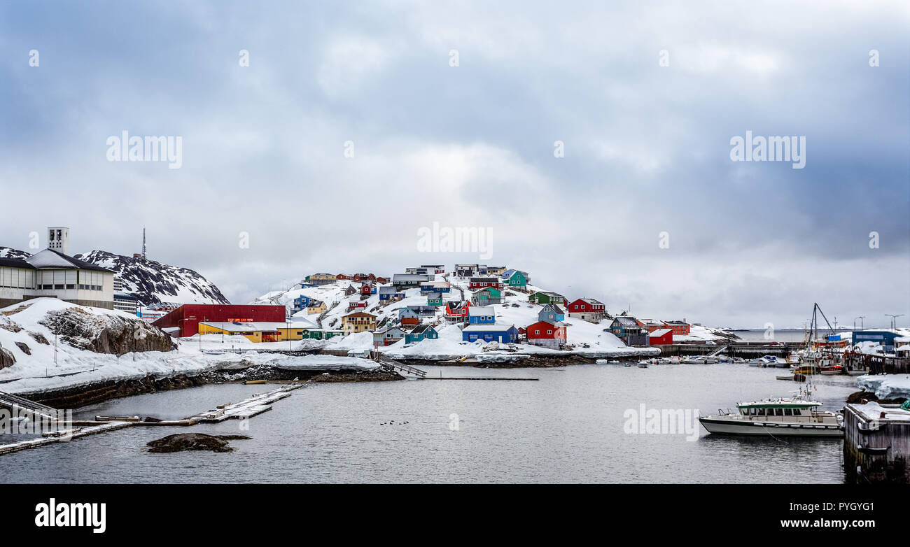 Porto con barche e colorate case Inuit sulle rocce in background, Maniitsoq città Groenlandia Foto Stock