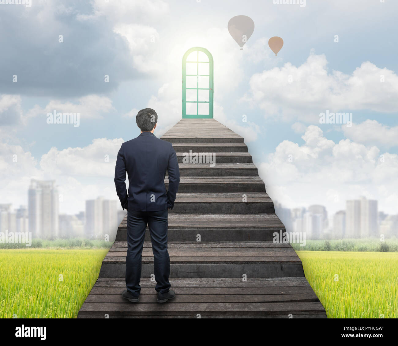 Imprenditore in piedi per camminare su per le scale per la porta sull'erba e cityscape sfondo,il successo aziendale e ambizioni concept Foto Stock