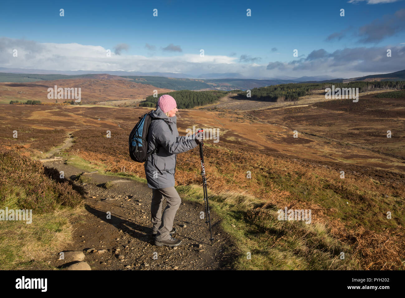 Walker seguendo il sentiero che scende dalla montagna di Schiehallion in Perth and Kinross, Scotland, Regno Unito Foto Stock