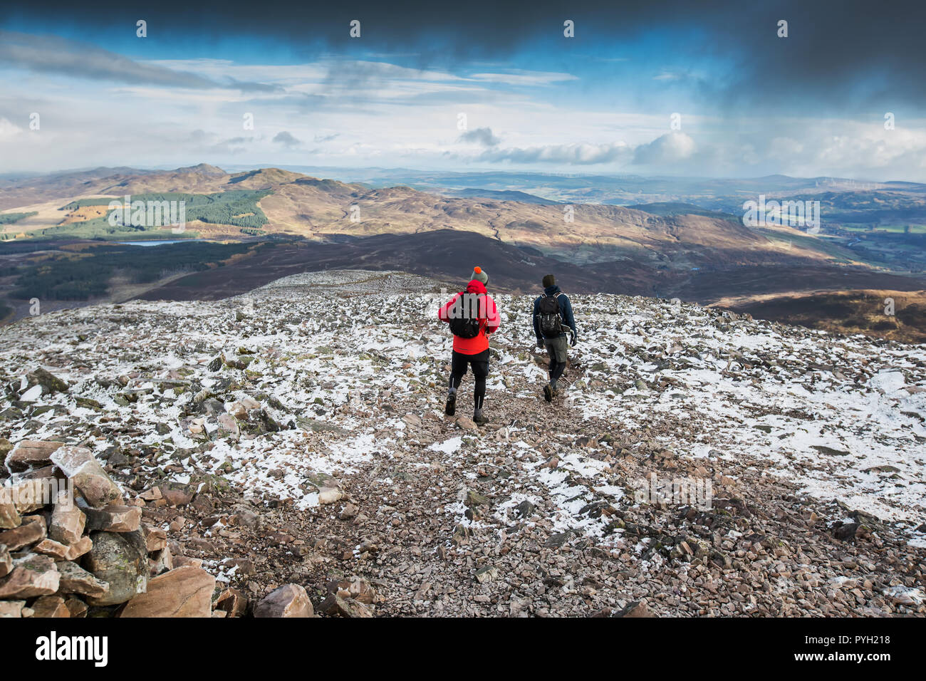 Walkers scendendo dalla vetta della montagna di Schiehallion in Perth and Kinross, Scozia, con una spolverata di neve Foto Stock