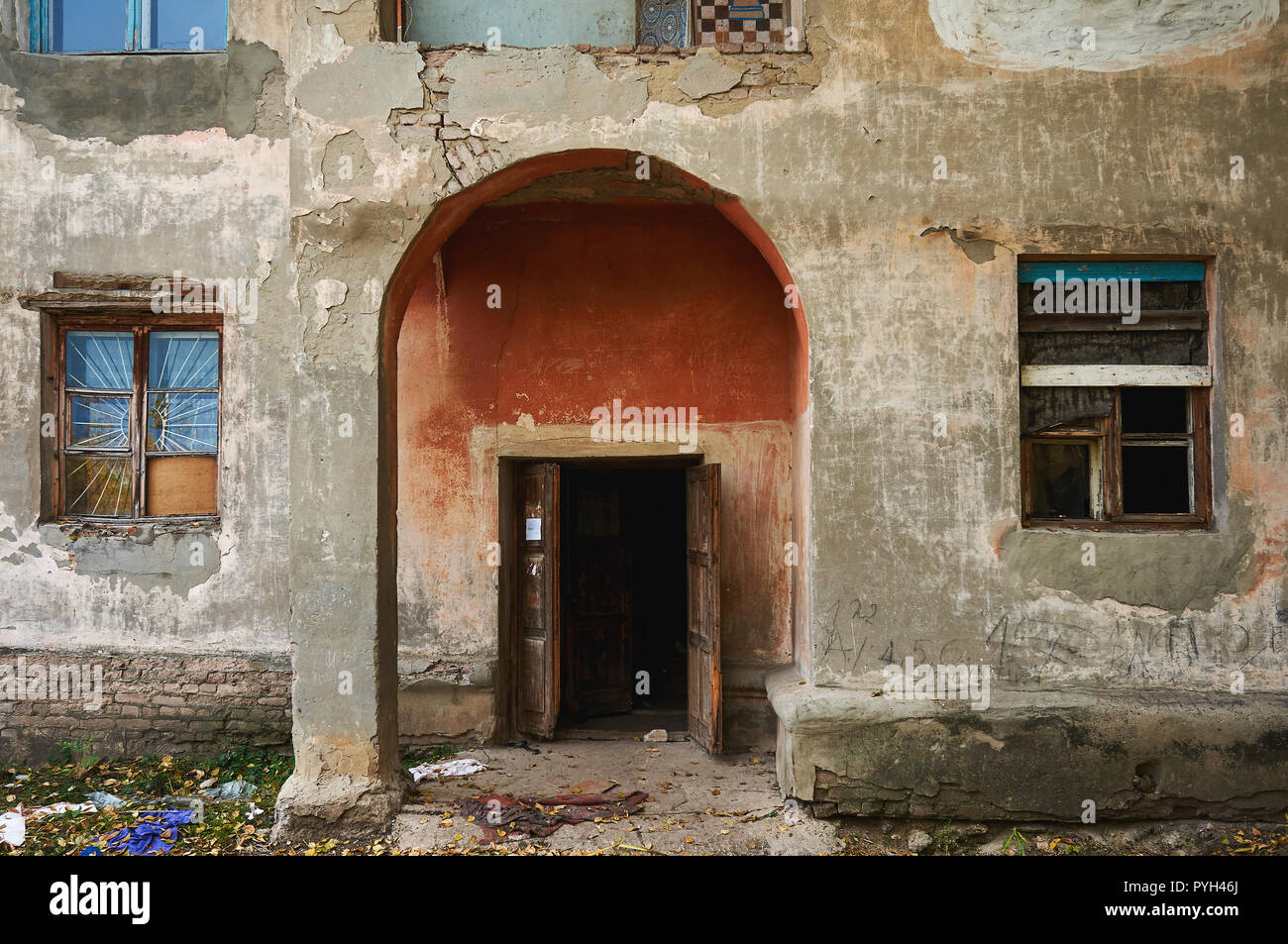 Una vecchia casa abbandonata con vetri rotti e crepe nella parete. Foto Stock