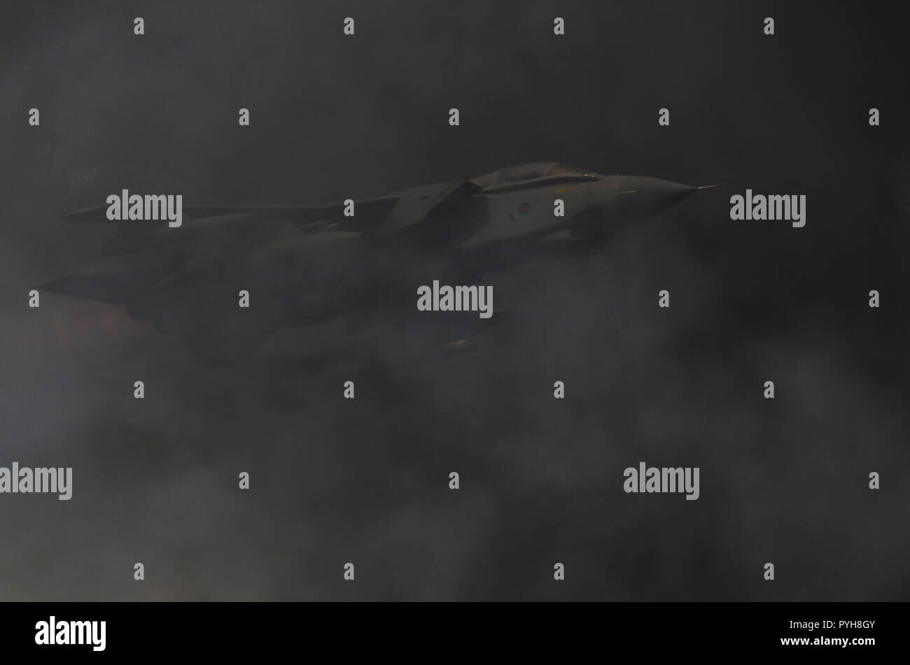 Dimostrazione di bombardamento di scenari di forza da parte della RAF, aereo da bombardamento a reazione Panavia Tornado della Royal Air Force. Volare attraverso il fumo dell'esplosione pirotecnica Foto Stock