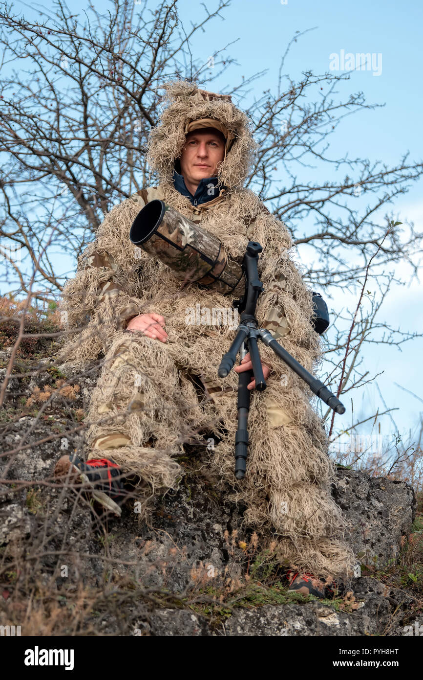 Il camuffamento Wildlife Photographer in Ghillie Suit lavora nel selvaggio Foto Stock