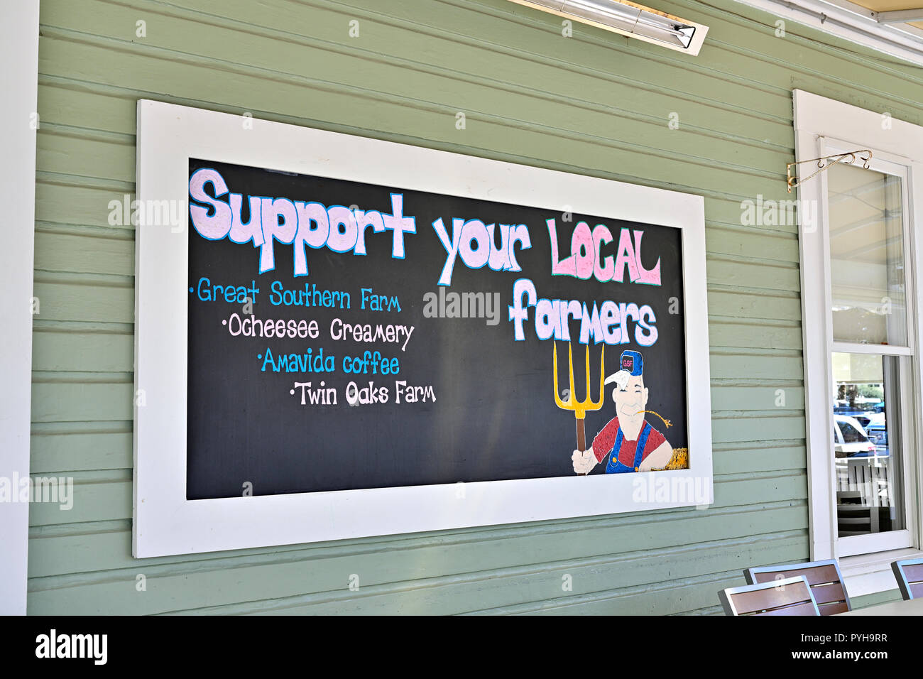 Il supporto per gli agricoltori locali segnale a parete del locale promuovere fonti di cibo in Seaside Florida, Stati Uniti d'America. Foto Stock