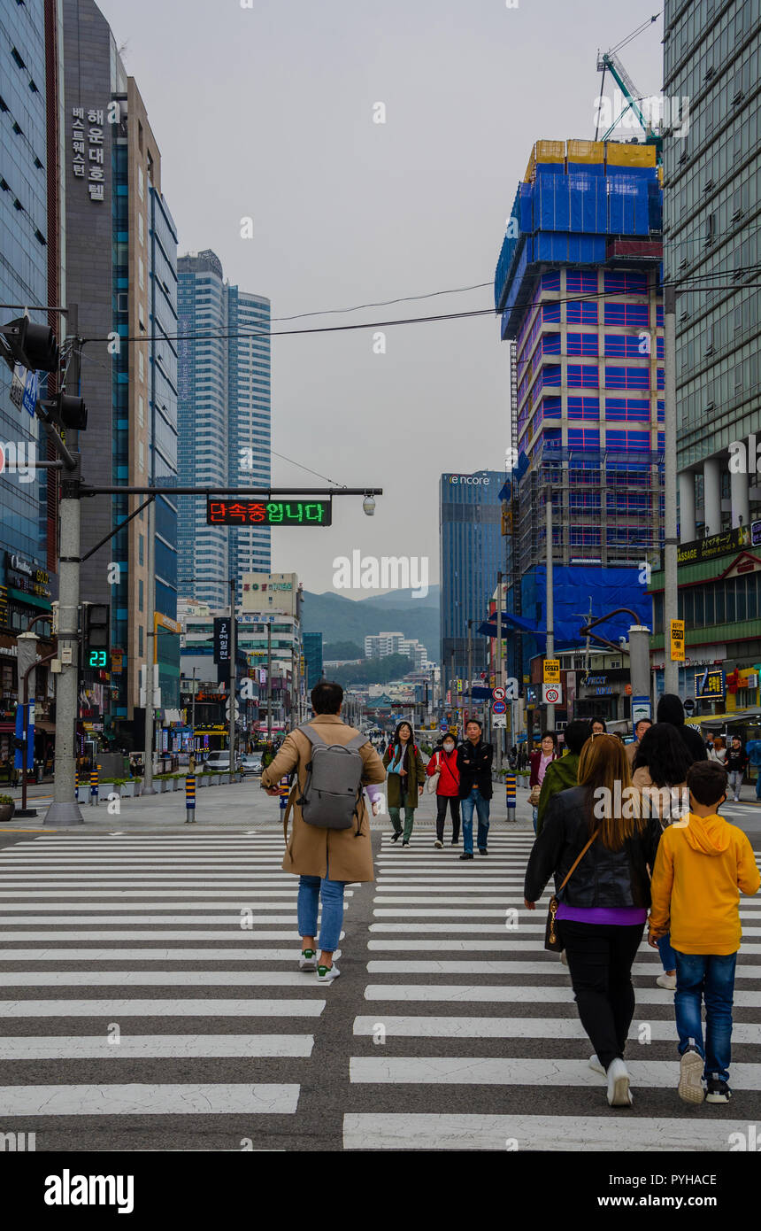 Persone attraversano la strada a un attraversamento pedonale in Haeundae, Busan, Corea del Sud. Foto Stock