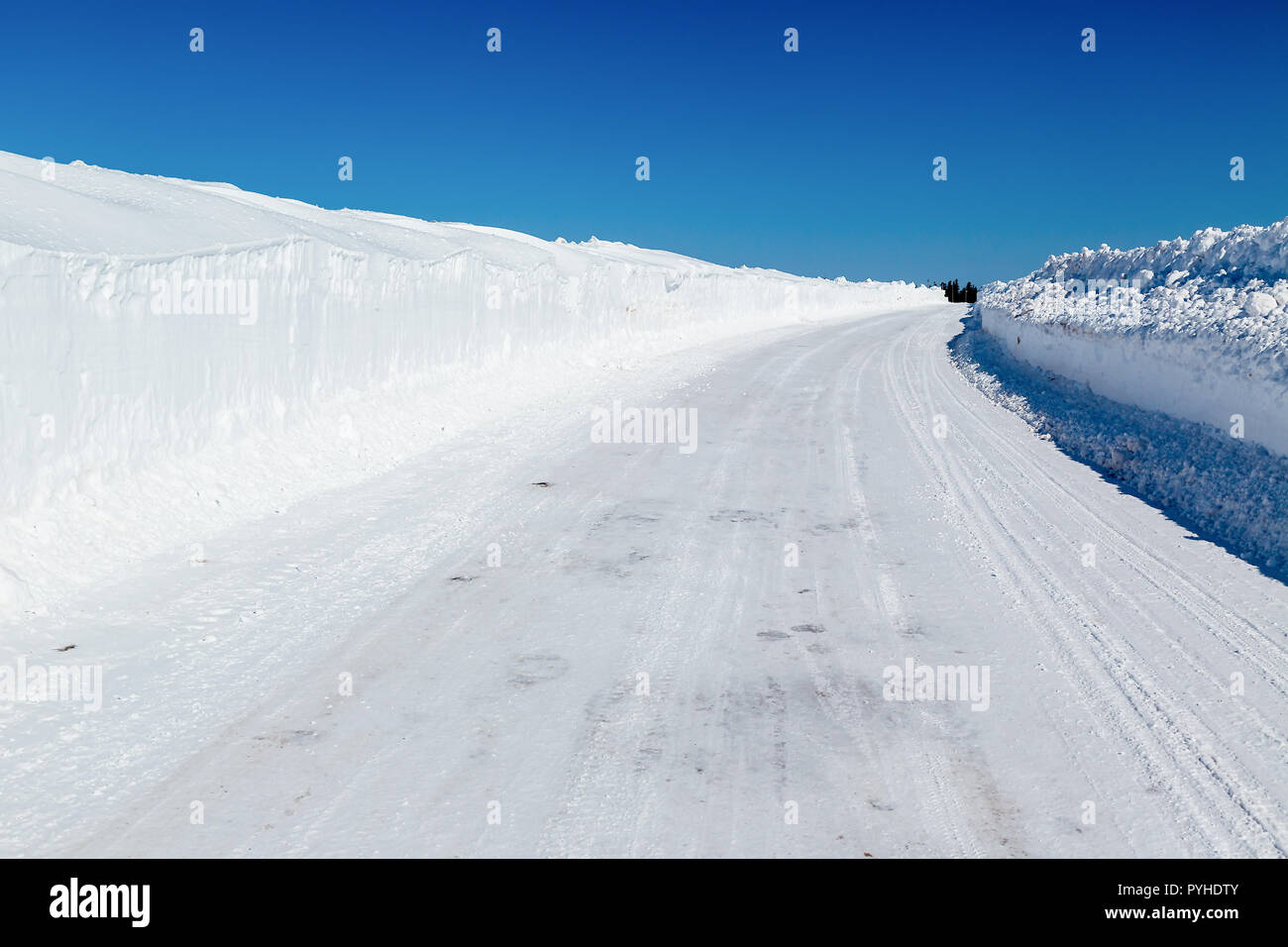 Strada invernale con alte snowbanks su ciascun lato. Foto Stock