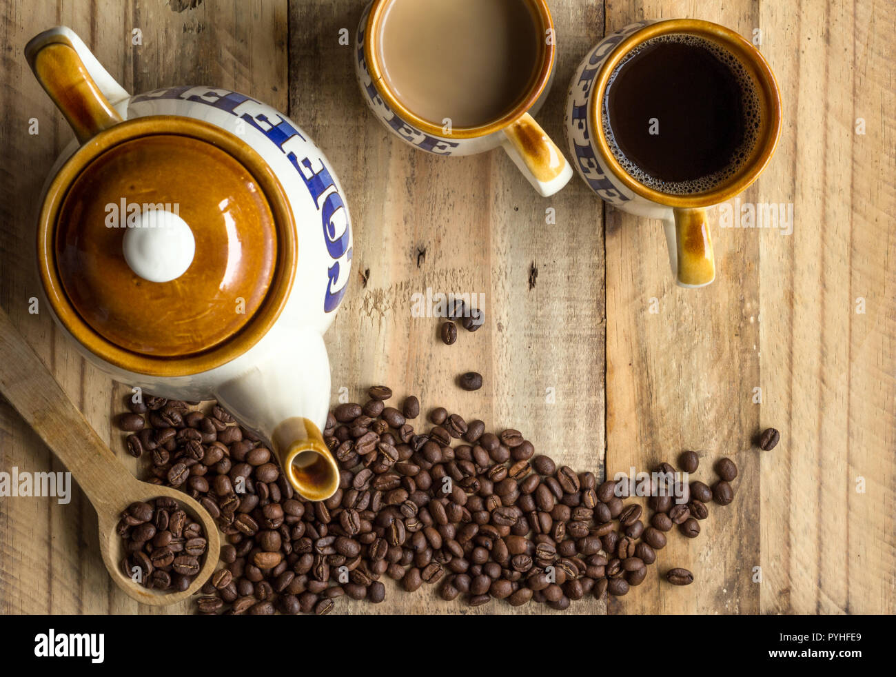Sfondo di caffè con caffè vintage pot, tazze e i chicchi di caffè sulla tavola in legno rustico - vista superiore foto con spazio per il testo Foto Stock