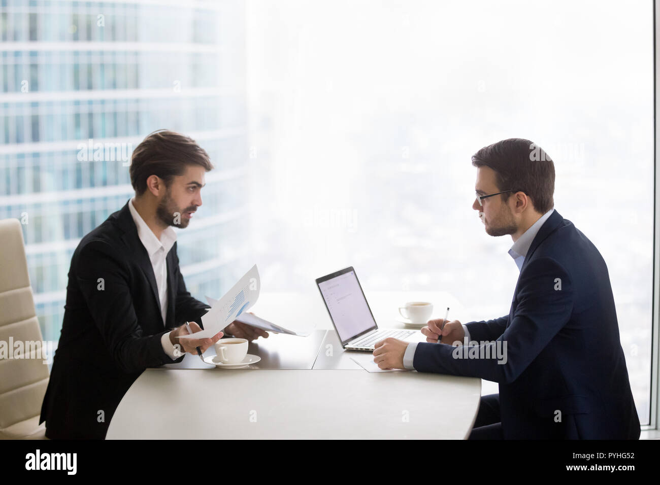 Due uomini stanno parlando e lavorare con documenti di office Foto Stock