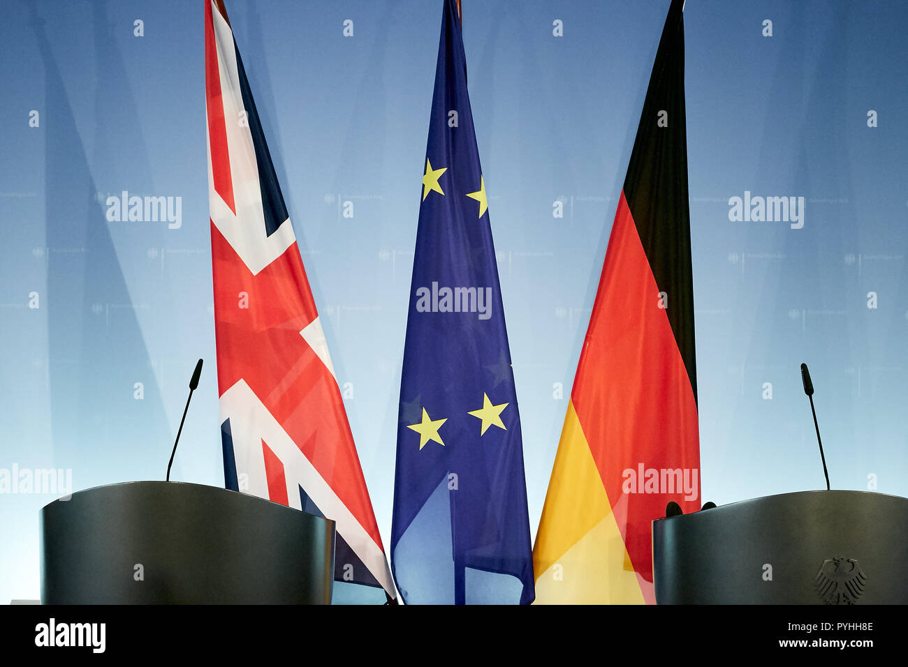 Berlino, Germania - Le bandiere della Gran Bretagna, l'Unione europea e la Germania appendere su standard dietro due scrivanie in piedi di fronte ad una parete del logo in una sala stampa del ministero degli Affari Esteri. Foto Stock