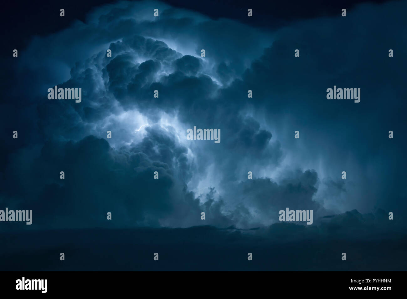 Blue Lightning Strike circondato da nuvole temporalesche. Foto Stock