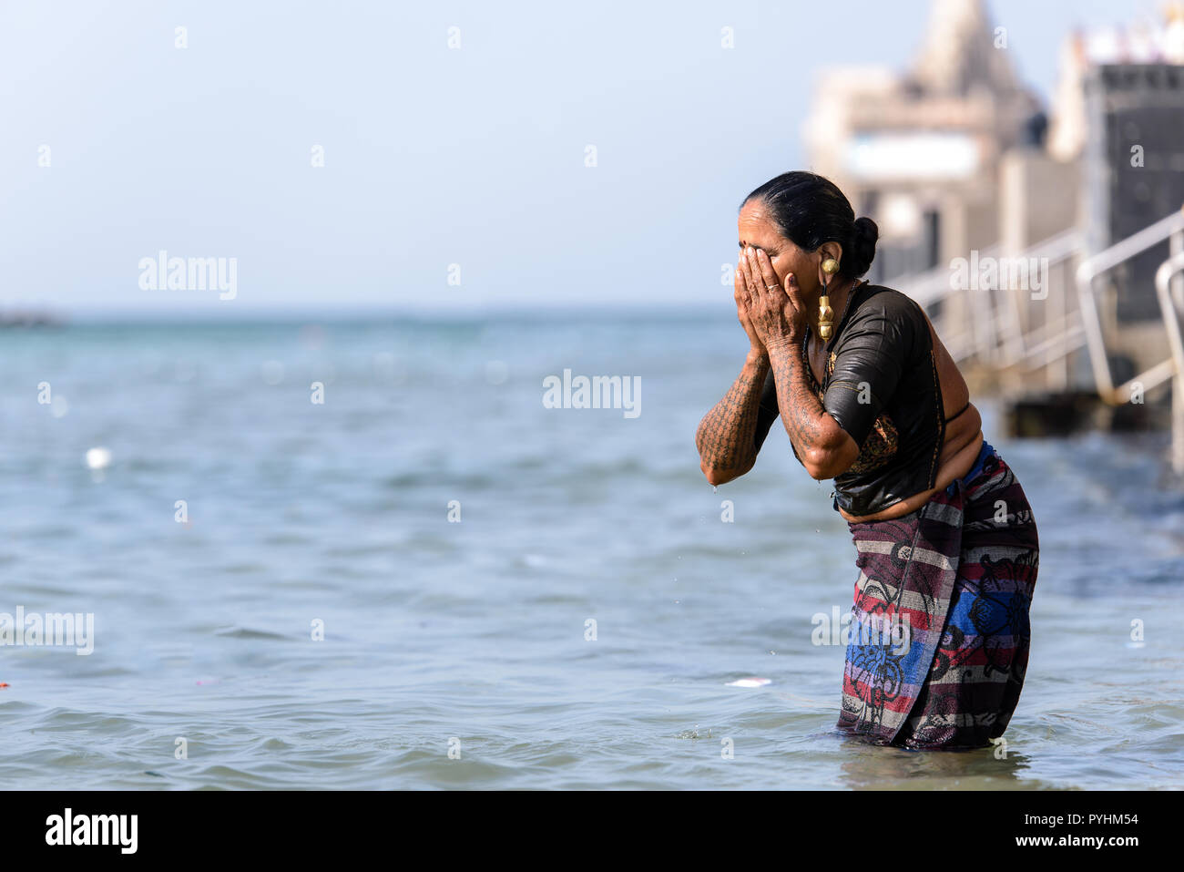 Indiano donna Indù facendo un tuffo nel santo Gomti fiume presso la città di Dwarka, Gujarat, India Foto Stock