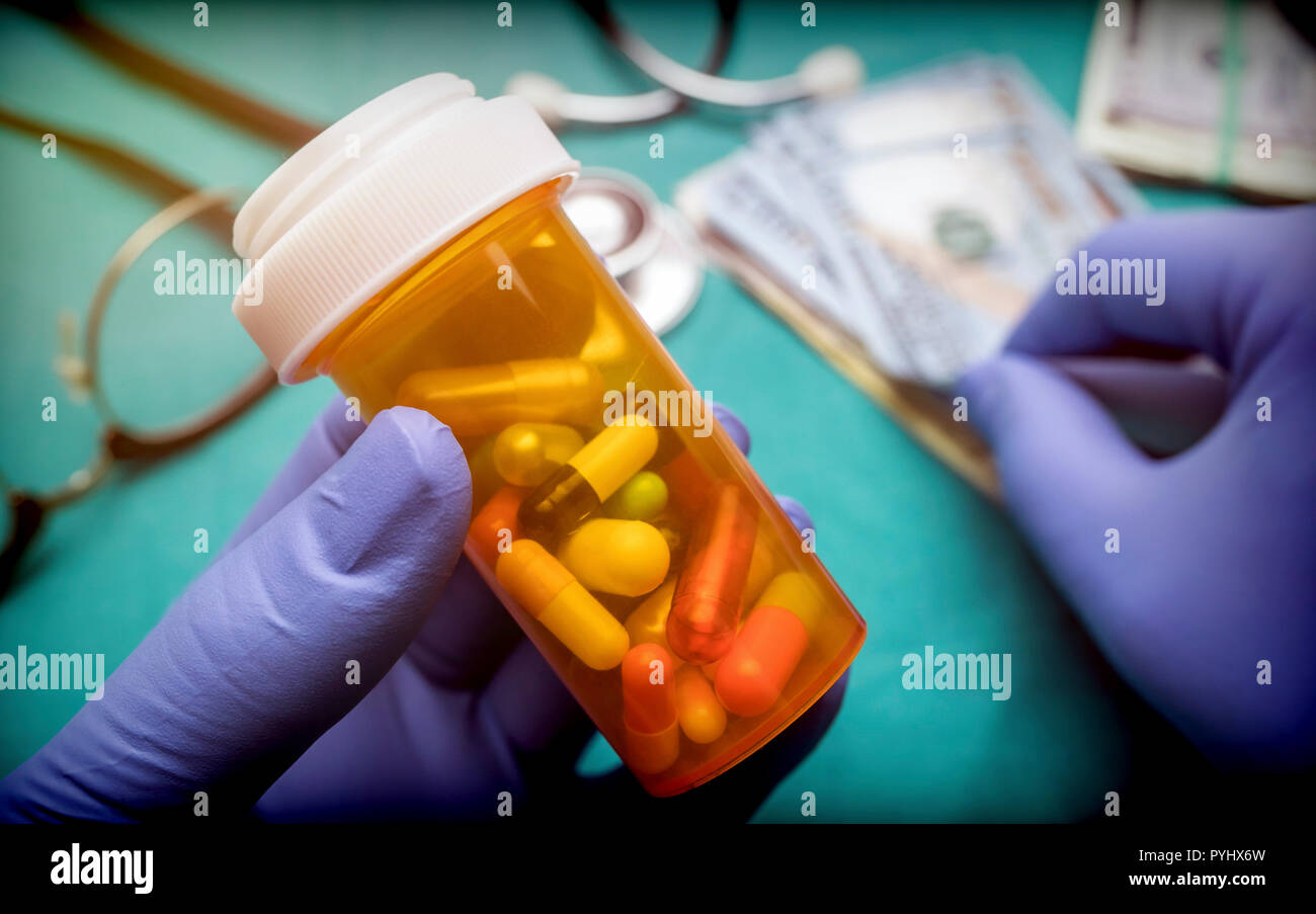 Medico supporta la barca con capsule di dimensioni diverse lungo con un paio di biglietti del dollaro americano, immagine concettuale Foto Stock
