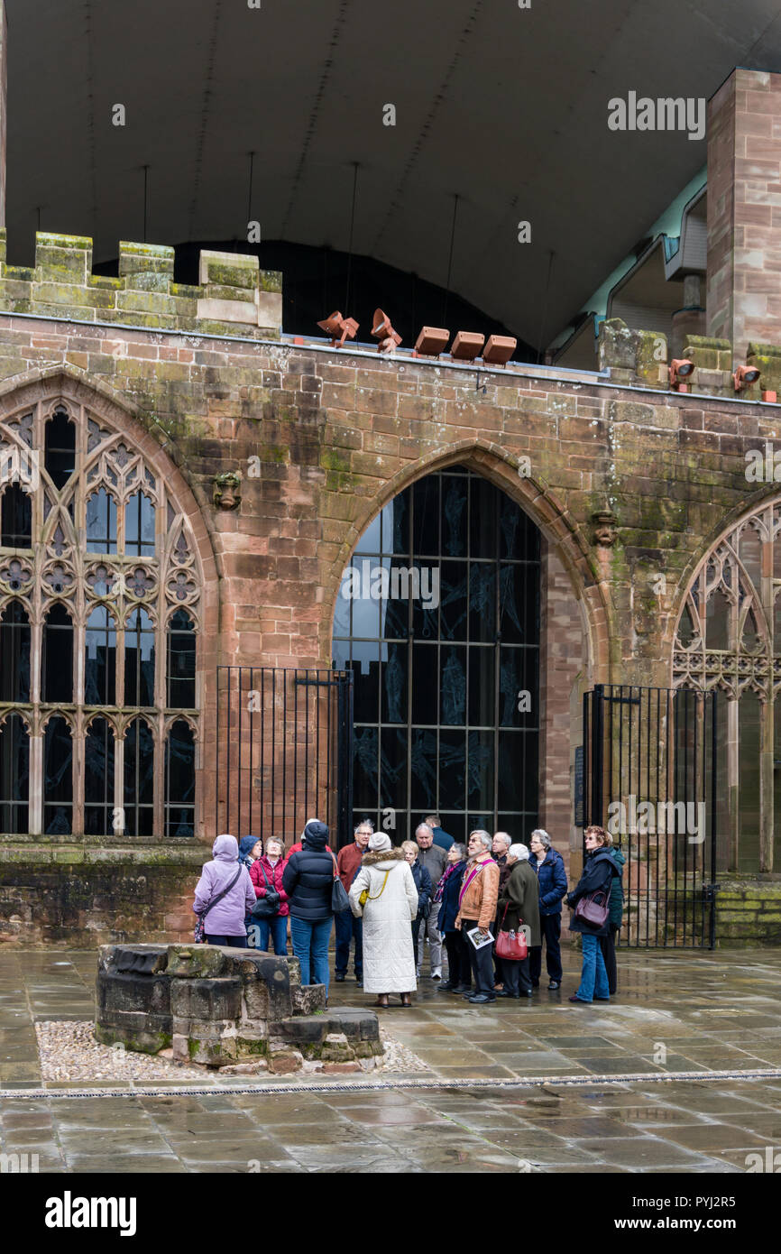 Un gruppo di anziani, membri dell'Università della terza età, in un tour guidato della cattedrale di Coventry, West Midlands, Regno Unito Foto Stock