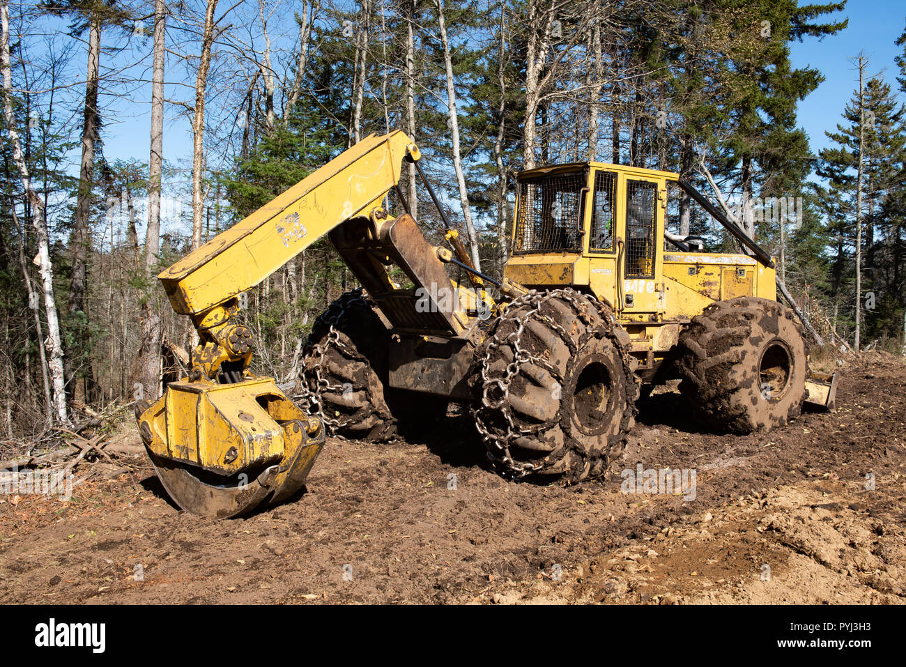 Un John Deere 548G la benna mordente trascinatronchi parcheggiato su un registro fangoso di sbarco nelle Montagne Adirondack, NY, STATI UNITI D'AMERICA foresta. Foto Stock