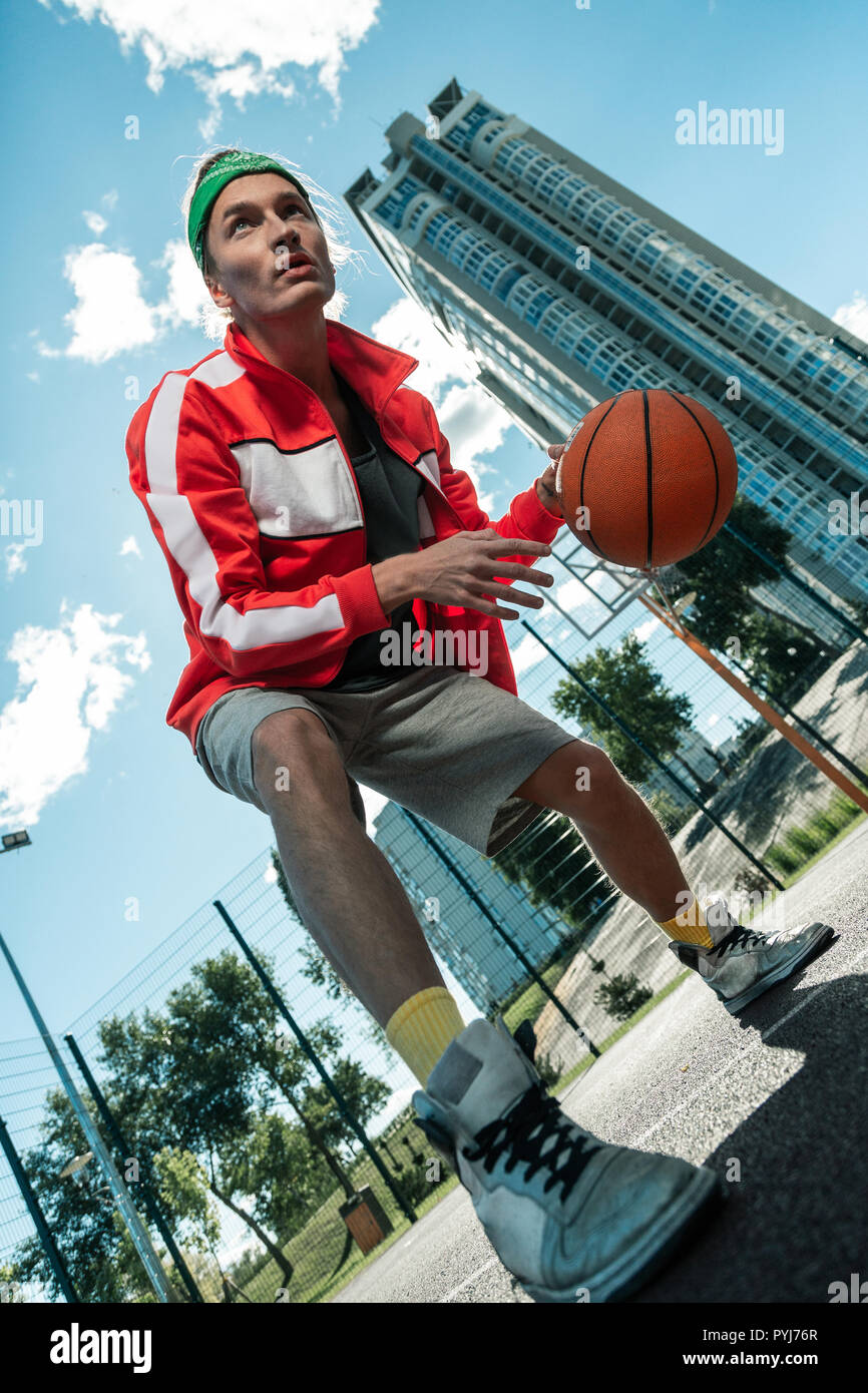 Basso angolo di un giovane serio giocare a basket Foto Stock