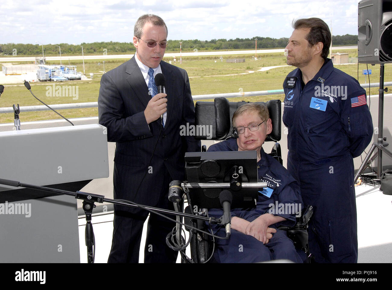2007 - ha osservato il fisico Stephen Hawking saluta i supporti dopo il suo arrivo presso il Kennedy Space Center Shuttle Landing Facility per la sua prima gravità zero volo. Foto Stock
