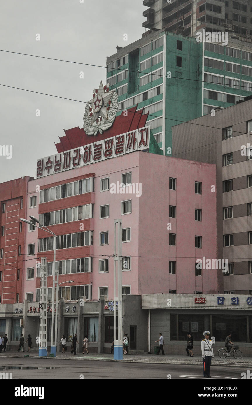 Il traffico di un funzionario di polizia regola il traffico con precisione militare a piazza centrale di Pyongyang di fronte alla principale stazione ferroviaria Foto Stock