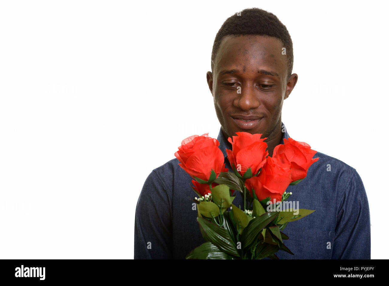 Bel giovane uomo africano holding rose rosse pronto per San Valentino Foto Stock