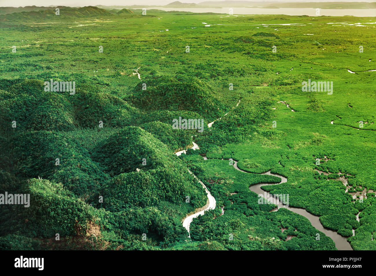 Vista aerea sul bellissimo tramonto sopra le montagne e il verde di mangrovie di foresta tropicale in Siargao island, Filippine. Foto Stock