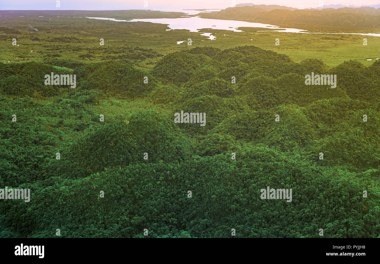 Vista aerea sul bellissimo tramonto sopra le montagne e il verde di mangrovie di foresta tropicale in Siargao island, Filippine. Foto Stock