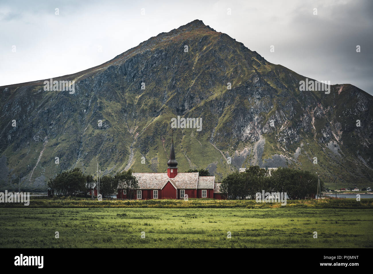 Chiesa di Flakstad con le montagne sullo sfondo, squisita del XVIII secolo capolavoro barocco in Artico, Flakstadoy, Isole Lofoten, a nord del Foto Stock