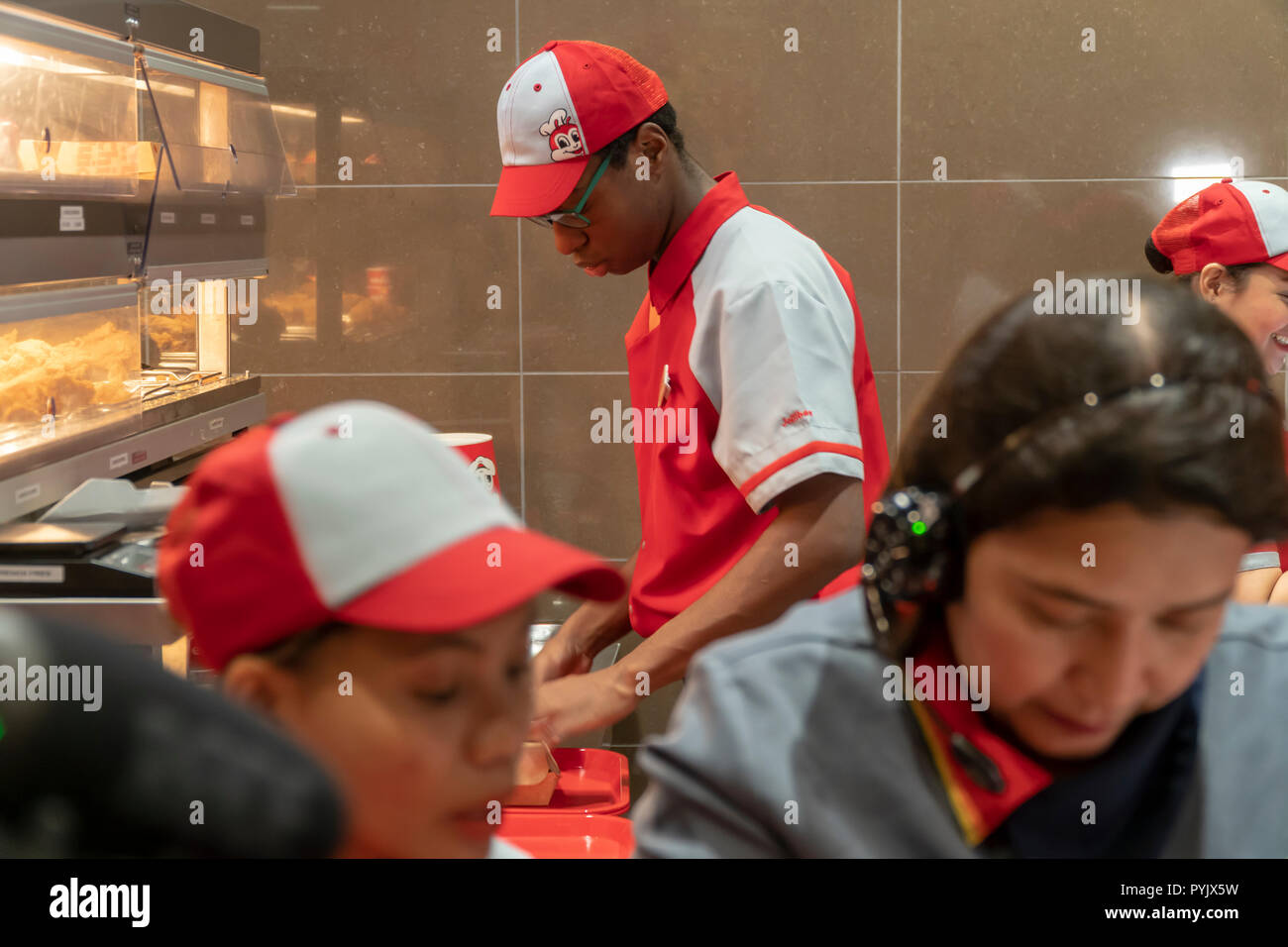 New York, Stati Uniti d'America. 28 ott 2018. I lavoratori di fretta per preparare gli ordini nel Jollibee fast food ristorante nel centro di Manhattan a New York il giorno di apertura Sabato, Ottobre 27, 2018 . Il ristorante della catena, che è stato battezzato il Philippine McDonald's a causa della sua ubiquità e popolarità nel paese, ha aperto la sua prima posizione a Manhattan nella zona di Times Square. Jollibee Foods Corp., che ha dei piani per aprire centinaia di negozi negli Stati Uniti e il Canada detiene anche una partecipazione nella catena Smashburger. (Â© Richard B. Levine) Credito: Richard Levine/Alamy Live News Foto Stock