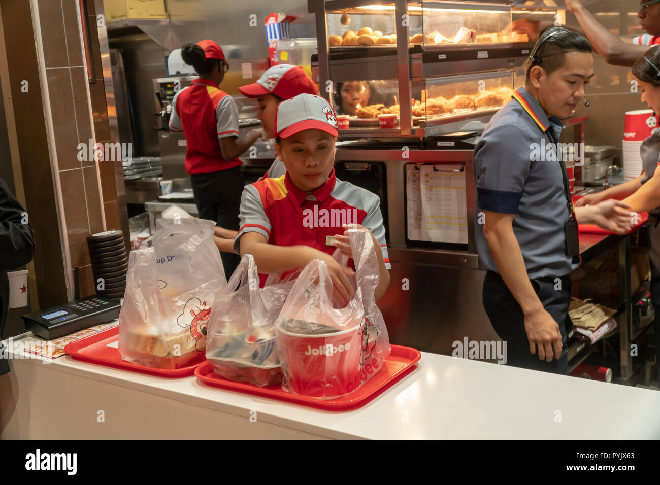 New York, Stati Uniti d'America. 28 ott 2018. I lavoratori di fretta per preparare gli ordini nel Jollibee fast food ristorante nel centro di Manhattan a New York il giorno di apertura Sabato, Ottobre 27, 2018 . Il ristorante della catena, che è stato battezzato il Philippine McDonald's a causa della sua ubiquità e popolarità nel paese, ha aperto la sua prima posizione a Manhattan nella zona di Times Square. Jollibee Foods Corp., che ha dei piani per aprire centinaia di negozi negli Stati Uniti e il Canada detiene anche una partecipazione nella catena Smashburger. (Â© Richard B. Levine) Credito: Richard Levine/Alamy Live News Foto Stock