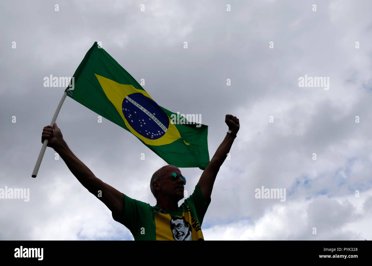 Rio De Janeiro, Brasile. 28 ott 2018. Un sostenitore sventola una bandiera brasiliana di fronte alla casa di estrema destra il candidato presidenziale Bolsonaro. Il favorito nella run-off è stato Bolsonaro, chi insulta ripetutamente le minoranze e provoca il loro slogan estremisti. "Democrazia è in gioco oggi", ha detto contatore-candidato Haddad di sinistra Partito dei lavoratori dopo la votazione in São Paulo. Credito: Fabio Teixeira/dpa/Alamy Live News Foto Stock