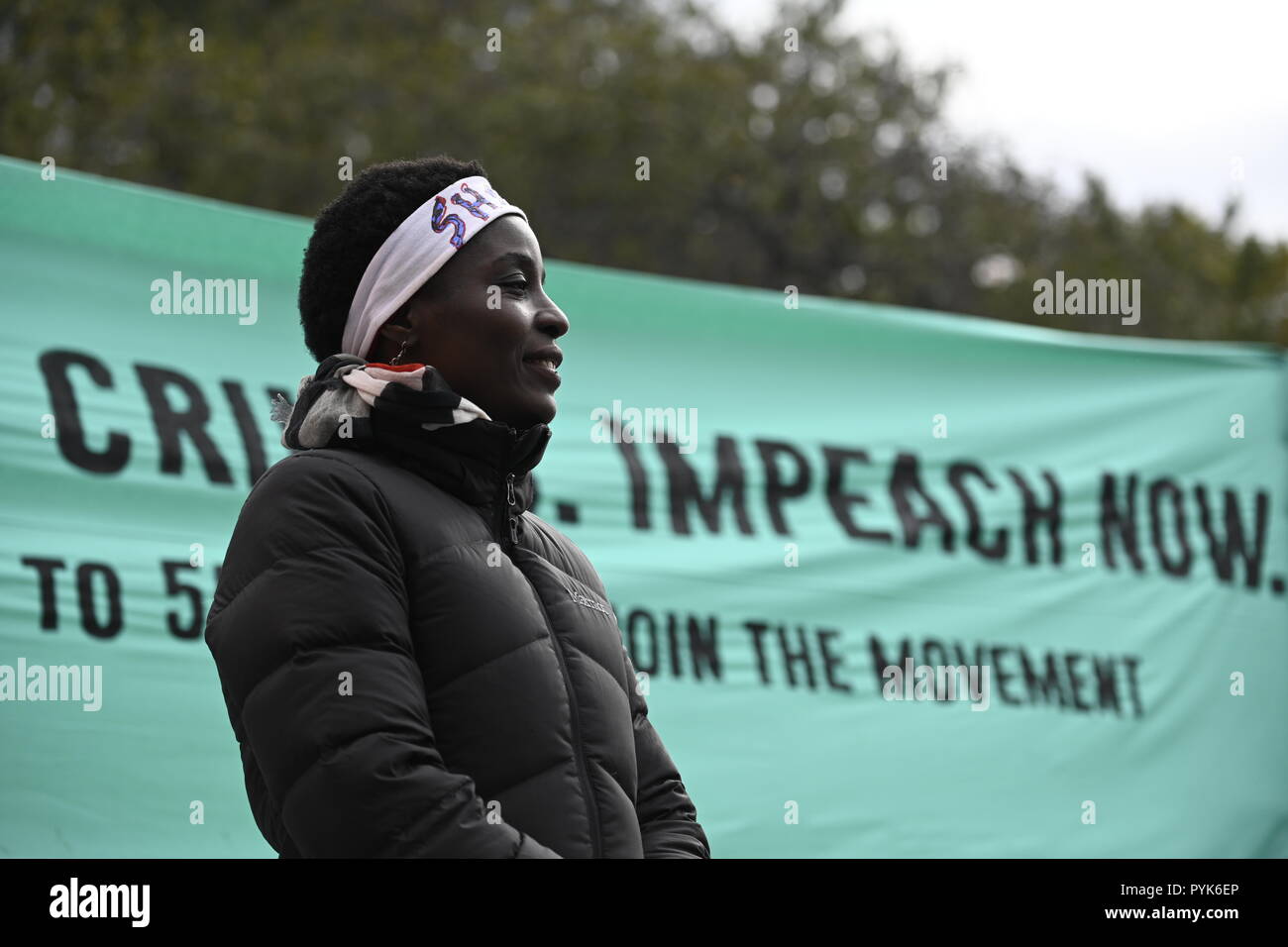 New York, Stati Uniti Il 28 ottobre 2018. Statua della Libertà scalatore Patricia Okoumou parla ai manifestanti che chiede di impeachment del presidente Donald Trump in un rally di New York Battery Park. Okoumou, un Congo native, facce prova nella corte federale a Manhattan sul Dic 17 sulle spese relative al suo atto di disobbedienza civile il 4 luglio quando ha scalato il piedistallo della Statua della Libertà per protestare contro la Trump administration le politiche di immigrazione. Credito: Joseph Reid/Alamy Live News Foto Stock