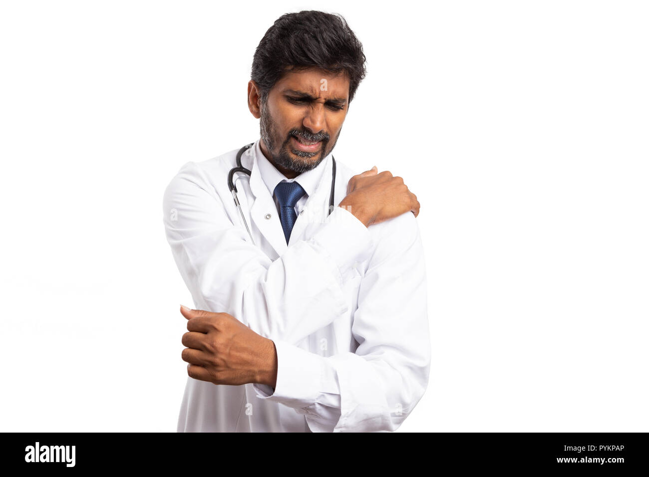 Indiano medico disperata toccando spalla slogata con espressione dolorosa isolati su sfondo bianco Foto Stock