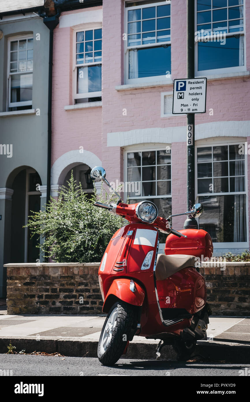 London, Regno Unito - 1 Agosto 2018: Rosso Vespa moto parcheggiata da una casa di Barnes, Londra. Vespa è un famoso marchio italiano di scooter fabbricati da Piagg Foto Stock