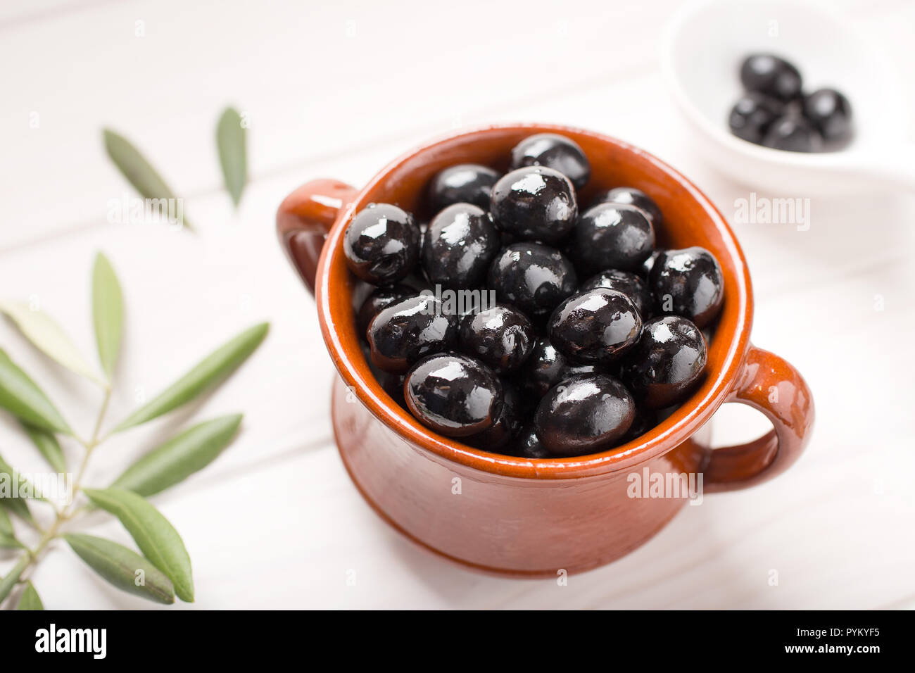 Olive nere nel recipiente rustico gustosi stuzzichini Foto Stock